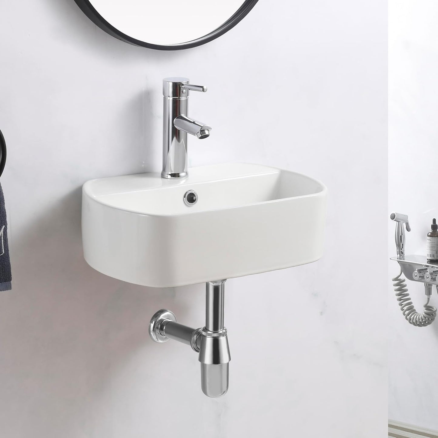 Compact wall hung basin with a smooth ceramic finish, installed in a minimalistic white bathroom.