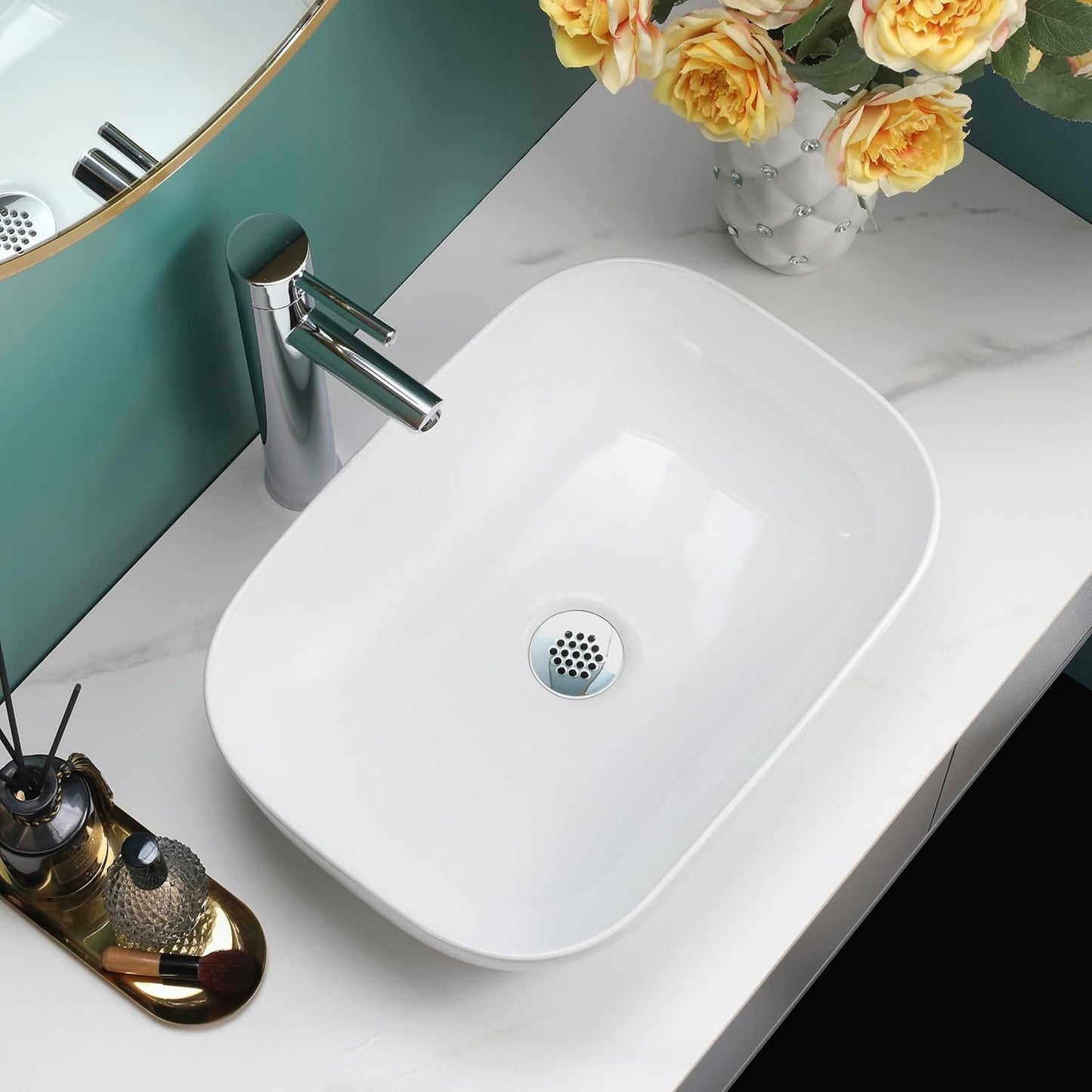 Gloss white rectangular counter top basin on a marble vanity with a green wall background.