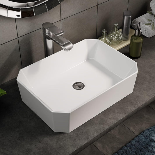 Modern white ceramic cloakroom basin with octagonal design on a dark countertop.