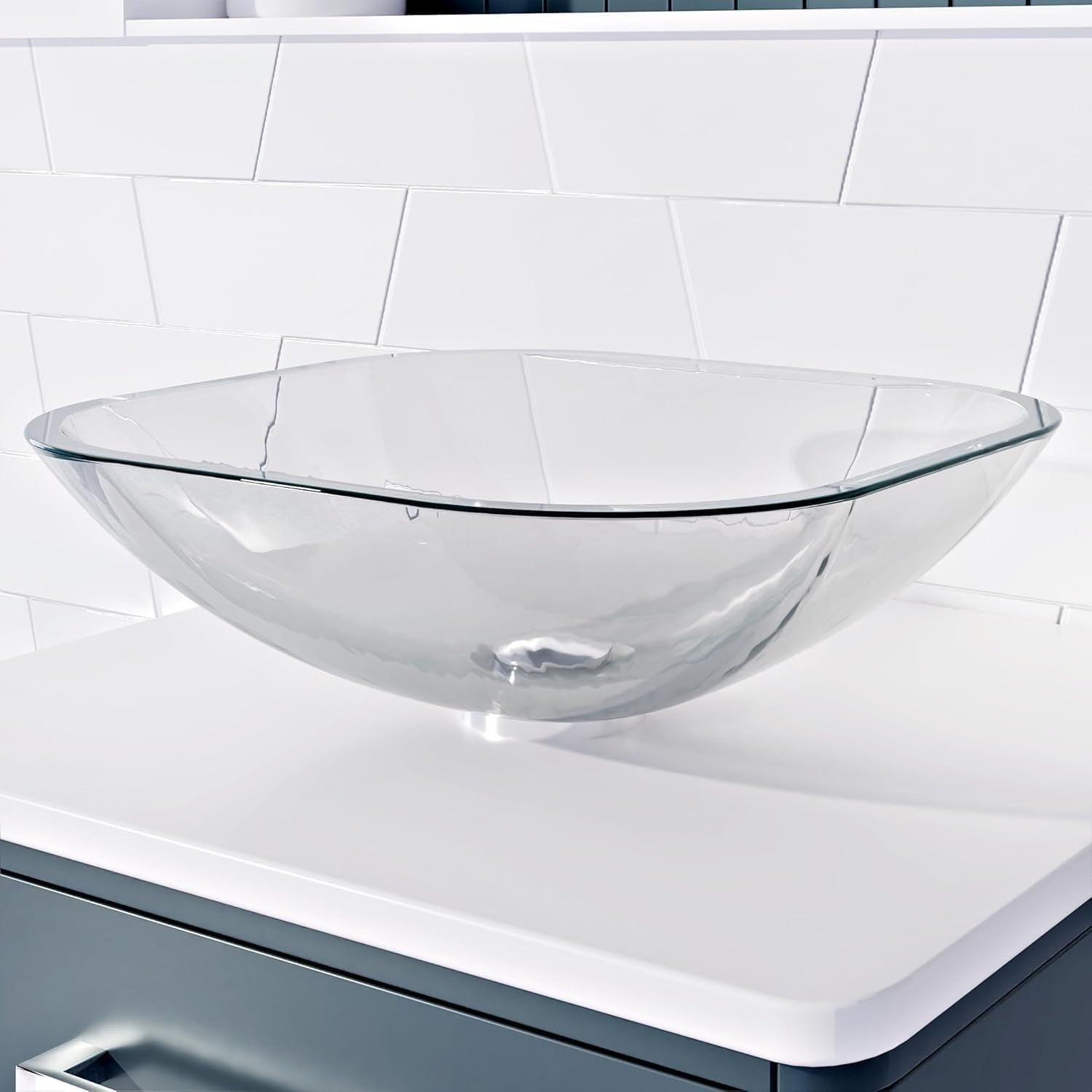 Close-up of rectangular glass basin on white countertop in bathroom.