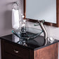 Rectangular glass basin with modern curved faucet on dark countertop.