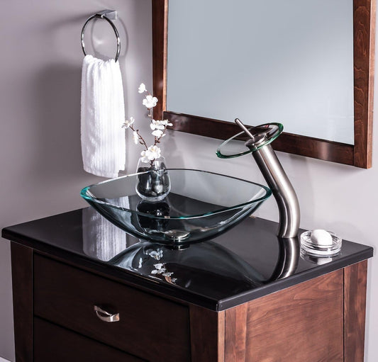 Rectangular glass basin with modern curved faucet on dark countertop.